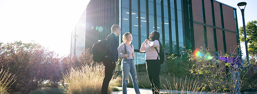 Exterior photo of academic building and students.